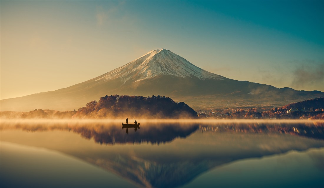 Mount Fuji soars upwards behind Lake Kawaguchiko at sunrise