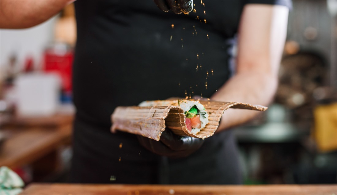 A chef puts the final touches on a traditional sushi roll