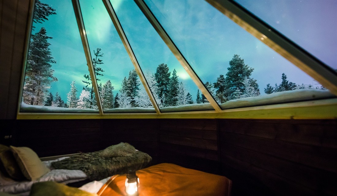 The northern lights viewed through the roof of an Aurora Cabin at Aurora Village. © Aurora Village