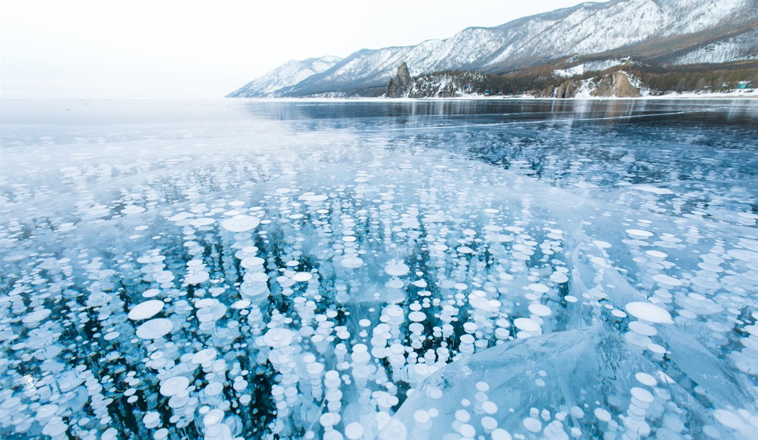 Lake Baikal is the world's oldest, deepest, clearest, and largest (by volume) freshwater lake. In the winter when it freezes, you may see methane bubbles frozen within the ice like this. © Shutterstock/Strelyuk